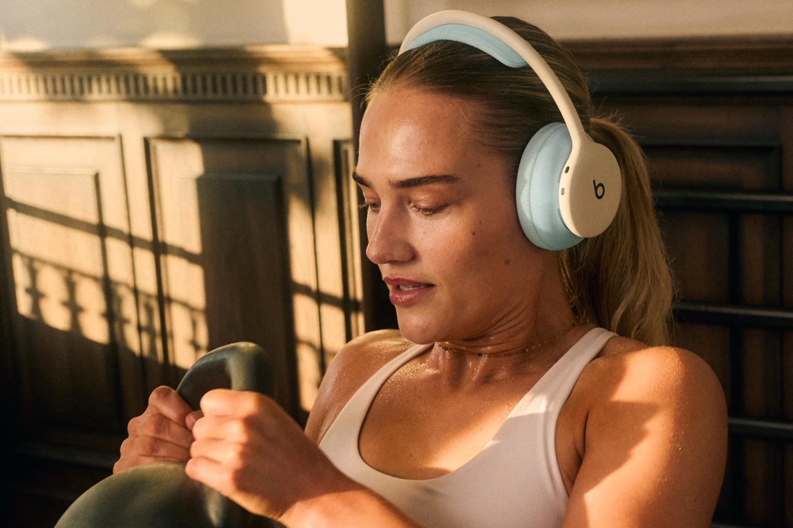 Casque Beats 360 en coloris Cloud et coussinets Sky porté pendant une séance de kettlebell