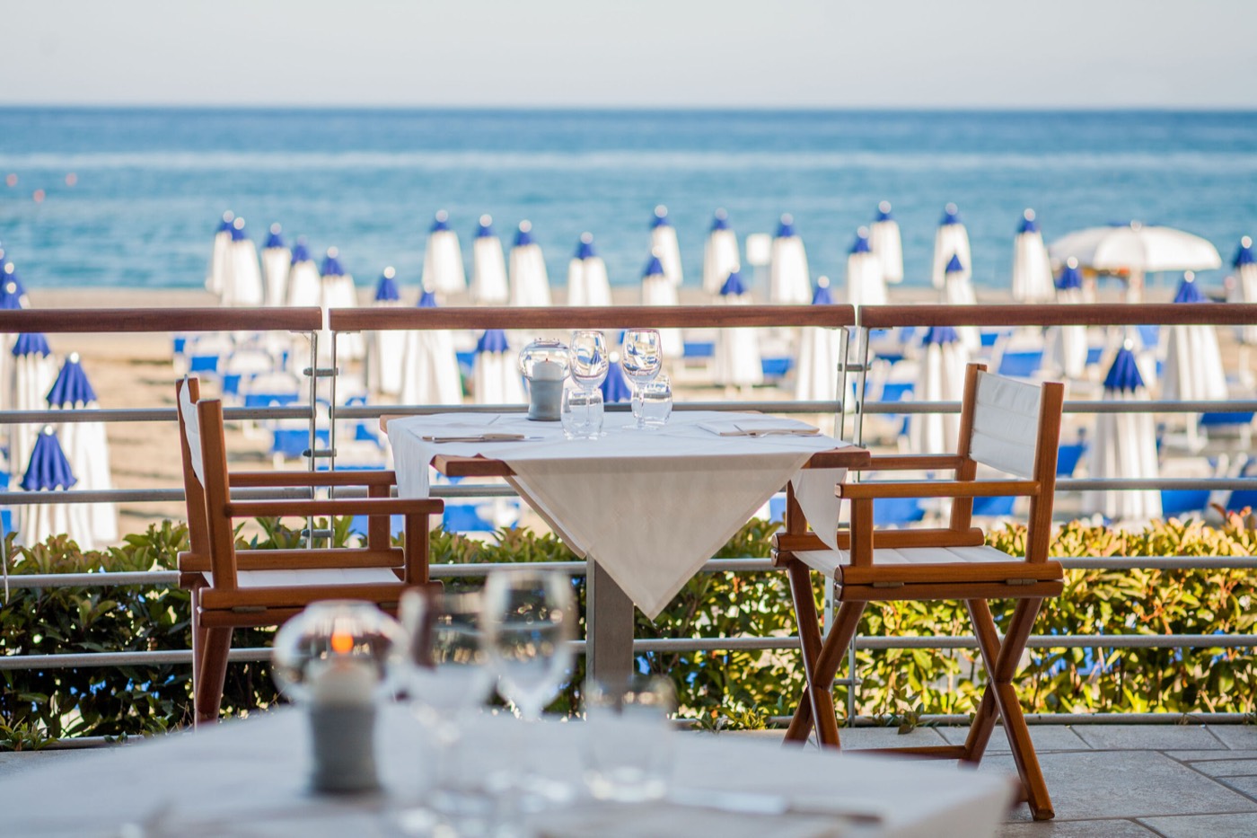 Tables dressées sur la terrasse du restaurant La Terrazza face à la plage