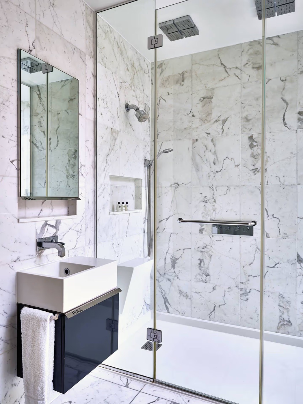 Salle de bains en marbre de l'Eccleston Square Hotel derrière sa cloison de verre
