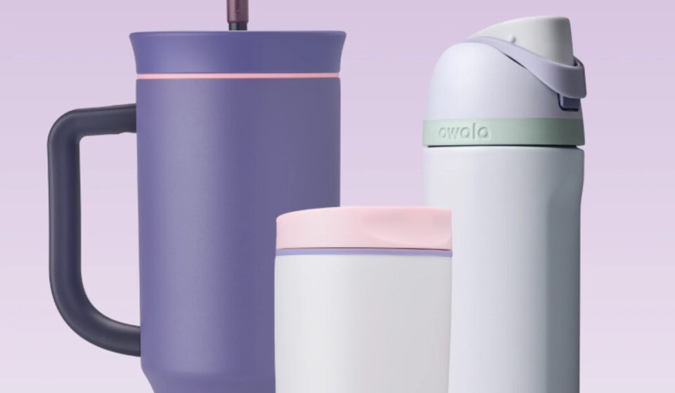 Trois gourdes Owala sur fond lilas : le gobelet 40 oz violet avec paille, un SmoothSip blanc et rose, et une FreeSip blanche